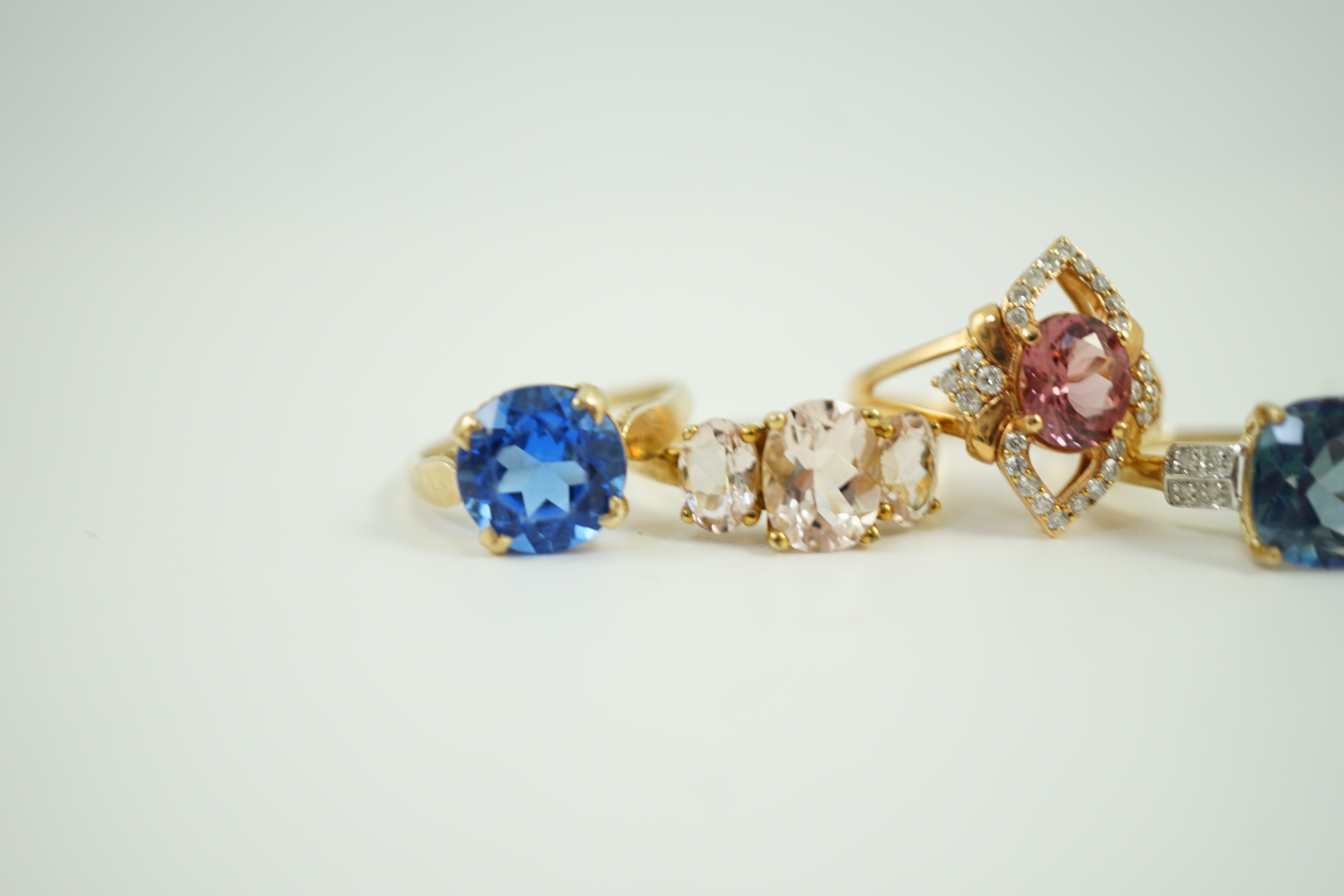 Four assorted modern 9ct gold and gem set rings and a similar 9k gem set ring, gross weight 16 grams.